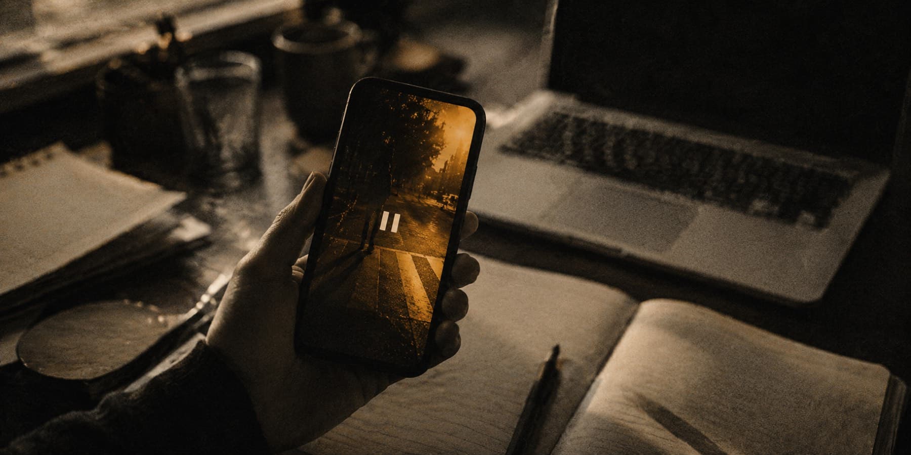 A creator at a desk, phone in hand, checking a video